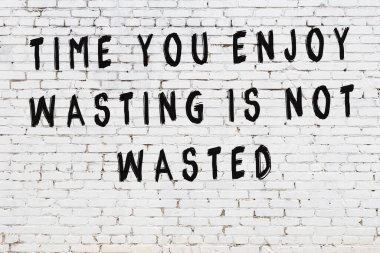 Beyaz tuğla duvar arkaplanına siyah düşünceli bir yazı.