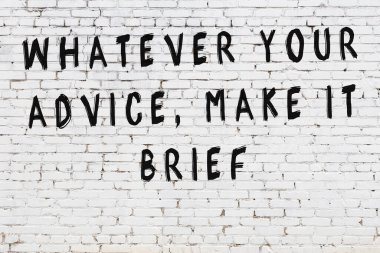 Beyaz tuğla duvara zekice alıntılar yazılı siyah bir yazı.