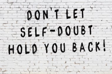 Bilgece alıntıların yazılı olduğu siyah boyanmış beyaz tuğla duvar