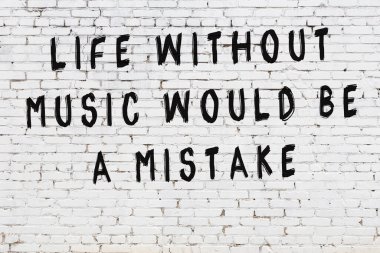 Beyaz tuğla duvar arkaplanına siyah düşünceli bir yazı.