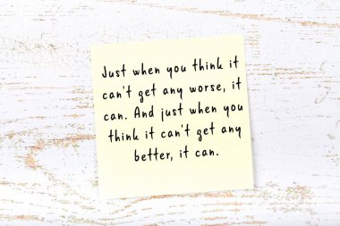 Ahşap duvardaki sarı yapışkan notta bilgece bir alıntı var.