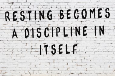 Bilgece alıntıların yazılı olduğu siyah boyanmış beyaz tuğla duvar