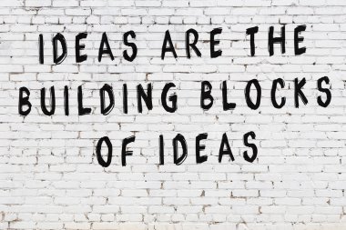 Beyaz tuğla duvar arkaplanına siyah düşünceli bir yazı.