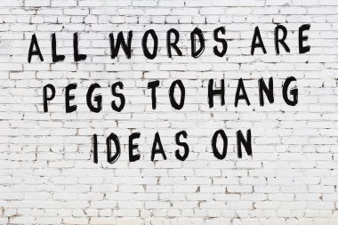 Beyaz tuğla duvar arkaplanına siyah düşünceli bir yazı.