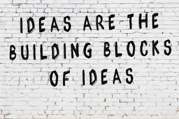 Beyaz tuğla duvar arkaplanına siyah düşünceli bir yazı.