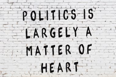 Beyaz tuğla duvar arkaplanına siyah düşünceli bir yazı.