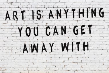 Beyaz tuğla duvar arkaplanına siyah düşünceli bir yazı.