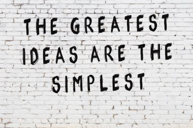 Beyaz tuğla duvar arkaplanına siyah düşünceli bir yazı.