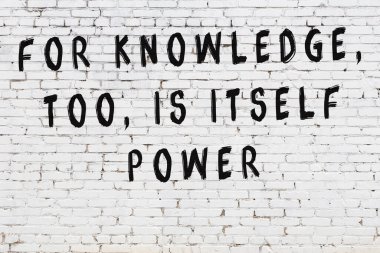 Bilgece alıntıların yazılı olduğu siyah boyanmış beyaz tuğla duvar