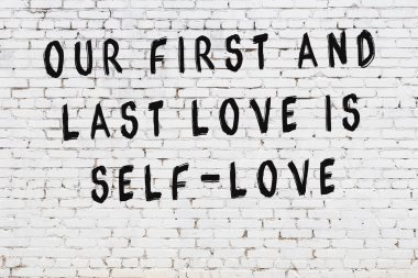 Beyaz tuğla duvar arkaplanına siyah düşünceli bir yazı.