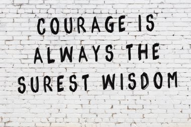 Bilgece alıntıların yazılı olduğu siyah boyanmış beyaz tuğla duvar