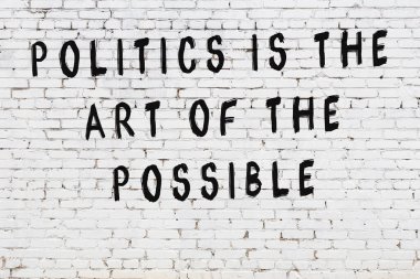 Beyaz tuğla duvar arkaplanına siyah düşünceli bir yazı.