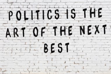 Beyaz tuğla duvar arkaplanına siyah düşünceli bir yazı.