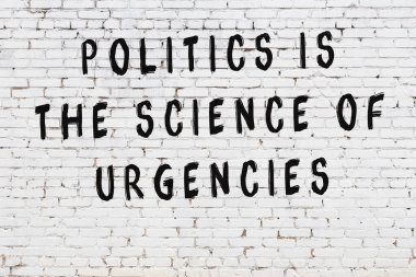 Beyaz tuğla duvar arkaplanına siyah düşünceli bir yazı.