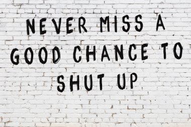 Beyaz tuğla duvar arkaplanına siyah düşünceli bir yazı.