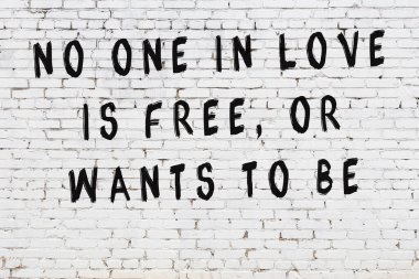 Beyaz tuğla duvar arkaplanına siyah düşünceli bir yazı.