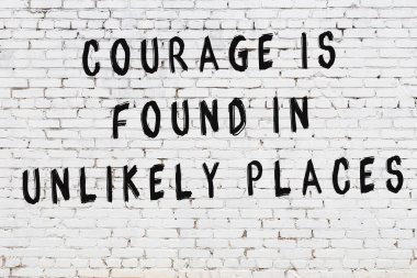 Beyaz tuğla duvar arkaplanına siyah düşünceli bir yazı.