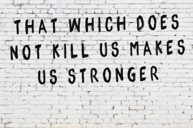 Beyaz tuğla duvar arkaplanına siyah düşünceli bir yazı.