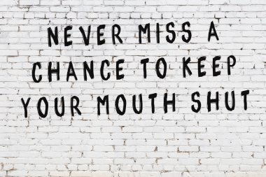 Beyaz tuğla duvar arkaplanına siyah düşünceli bir yazı.