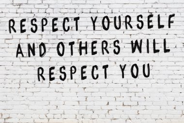 Bilgece alıntıların yazılı olduğu siyah boyanmış beyaz tuğla duvar