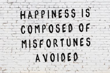 Beyaz tuğla duvar arkaplanına siyah düşünceli bir yazı.