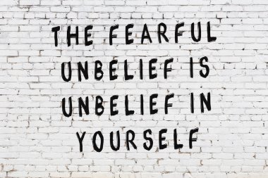 Beyaz tuğla duvar arkaplanına siyah düşünceli bir yazı.