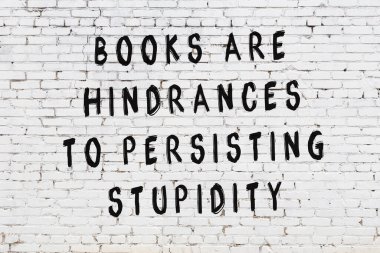 Beyaz tuğla duvar arkaplanına siyah düşünceli bir yazı.