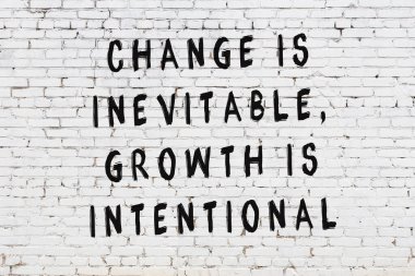 Beyaz tuğla duvar arkaplanına siyah düşünceli bir yazı.