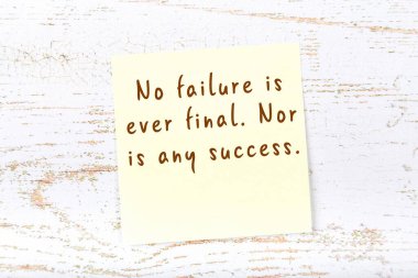 Ahşap duvardaki sarı yapışkan notta bilgece bir alıntı var.