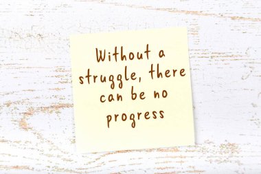 Ahşap duvardaki sarı yapışkan notta bilgece bir alıntı var.