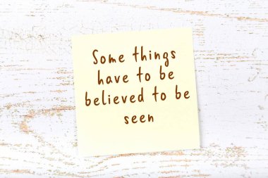 El yazısı motivasyon alıntısı olan sarı yapışkan not