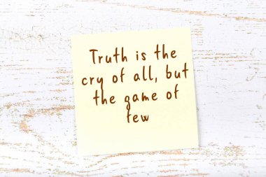 Ahşap duvardaki sarı yapışkan notta bilgece bir alıntı var.