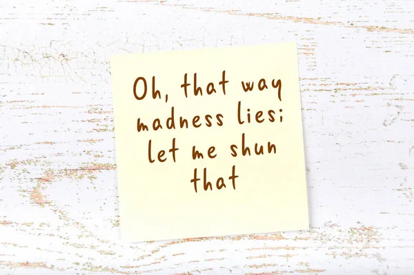 Желтая липкая нота на деревянной стене с мудрой цитатой — стоковое фото
