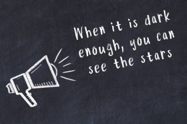 Tebeşir hoparlörü ve siyah masada akıllıca bir alıntı.