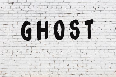 Üzerinde siyah boya yazılı hayalet olan beyaz duvar.