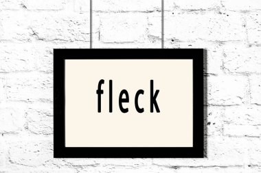 Beyaz tuğla duvarda asılı siyah çerçeve.