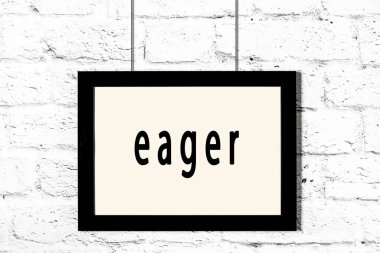 Beyaz tuğladan duvara asılmış siyah çerçeve.