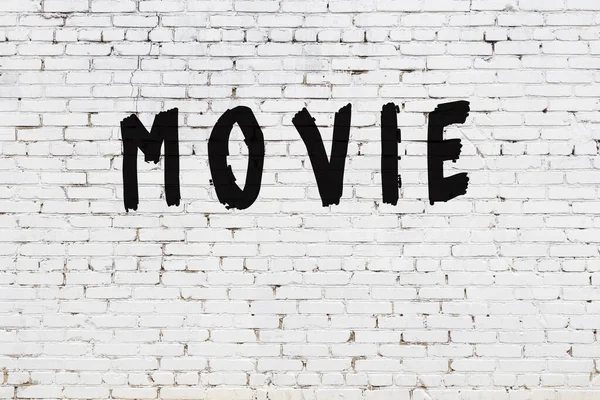 Ταινία λέξεων ζωγραφισμένη σε λευκό τοίχο από τούβλα — Φωτογραφία Αρχείου