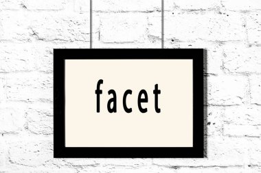 Beyaz tuğla duvarda asılı siyah çerçeve.