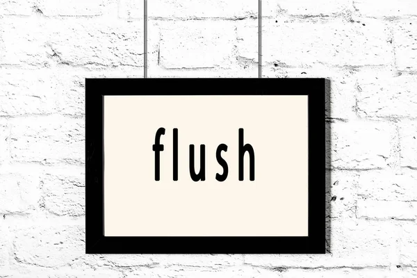 Quadro preto pendurado na parede de tijolo branco com flush inscrição — Fotografia de Stock