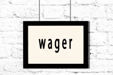 Beyaz tuğla duvarda asılı siyah çerçeve ve yazı bahsi