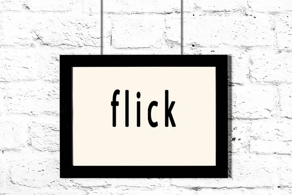 Quadro preto pendurado na parede de tijolo branco com flick inscrição — Fotografia de Stock