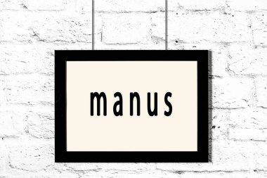 Beyaz tuğla duvarda asılı siyah çerçeve.