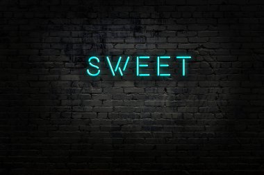 Üzerinde tuğla duvara karşı tatlı yazılar olan neon tabela