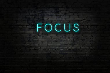 Üzerinde yazı olan neon işareti tuğla duvara odaklı