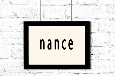 Beyaz tuğla duvarda asılı siyah çerçeve.