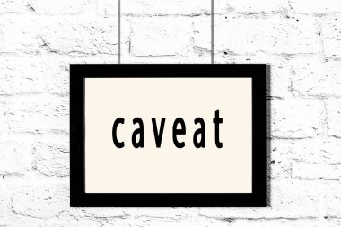 Beyaz tuğla duvarda asılı siyah çerçeve.