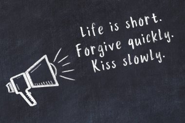 Tebeşir hoparlörü ve siyah masada akıllıca bir alıntı.