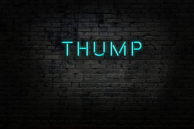 Üzerinde yazı olan neon levhası tuğla duvara çarpıyor