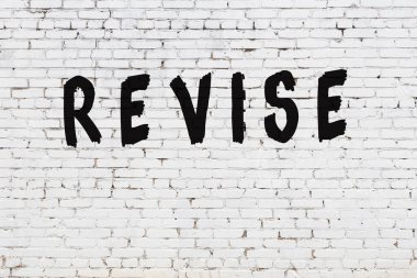 Üzerinde siyah boya yazıları olan beyaz duvar.